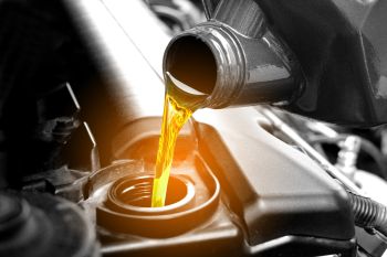 Motor oil being poured into a car engine through the oil filler opening